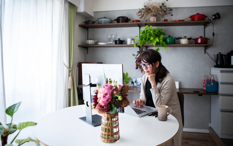 Woman using PowerSuite® Next on computer at home, accessing layoff support after a job loss. 