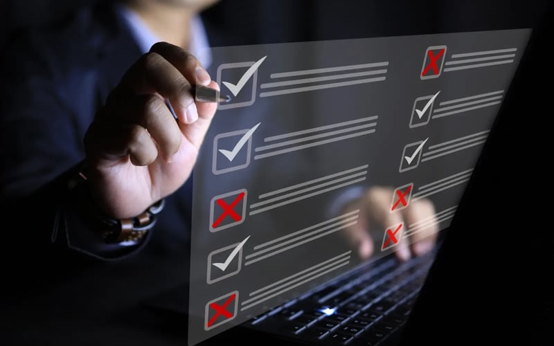 Female hand using a touchscreen filled with checkmarks and X’s representing workplace-based assessments 