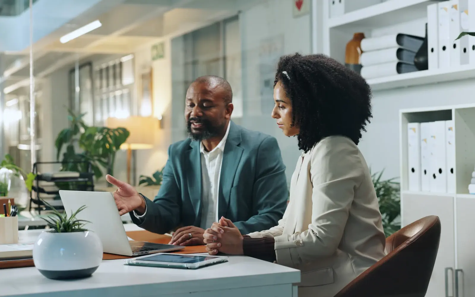 Outplacement coach works with a coachee at a desk to support career transition and preserve a talent network after layoffs. 
